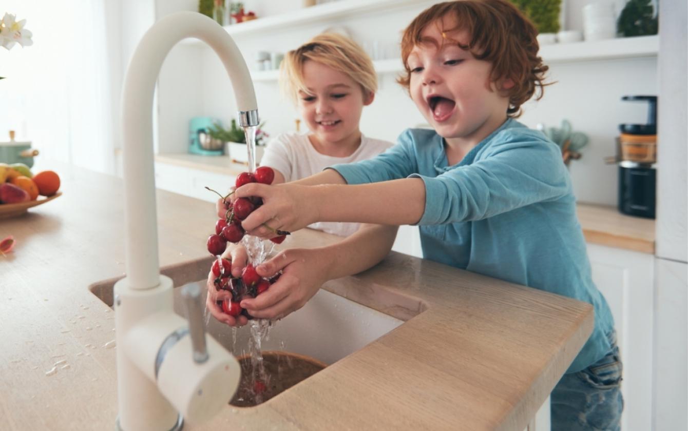 Dwoje dzieci myje ręce pod bieżącą wodą